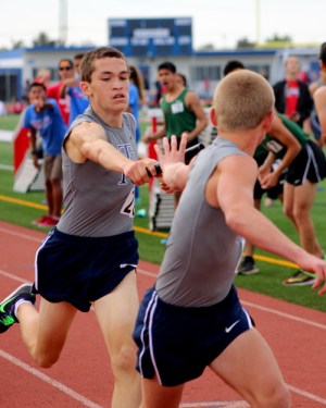 Jacob passes the baton to another runner in a relay race.